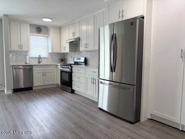 11 Ivy Rdg Unit 1000, Howell, NJ 07728 - kitchen featuring stainless steel appliances, under cabinet range hood, light wood-type flooring, and light countertops