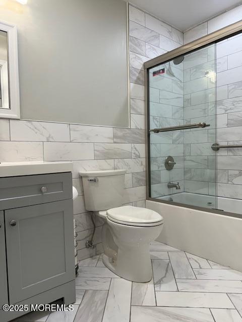 11 Ivy Rdg Unit 1000, Howell, NJ 07728 - bathroom featuring bath / shower combo with glass door, tile walls, vanity, and marble look tile flooring
