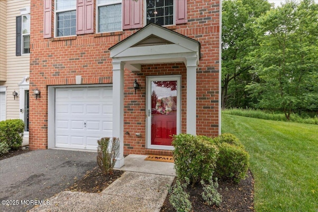 259 Chickadee Ct Unit 1000, Freehold, NJ 07728 - view of exterior entry featuring an attached garage, brick siding, and asphalt driveway