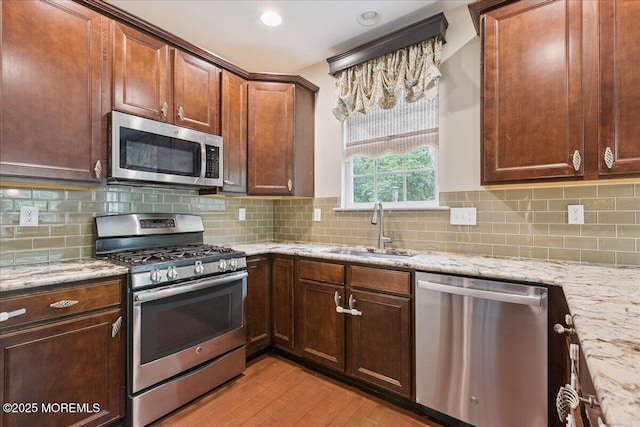 259 Chickadee Ct Unit 1000, Freehold, NJ 07728 - kitchen with stainless steel appliances, light wood-style flooring, light stone countertops, and decorative backsplash