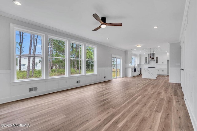 12 Outsail Ave, Barnegat, NJ 08005 - unfurnished living room featuring ornamental molding, a decorative wall, ceiling fan, wainscoting, and light wood-type flooring
