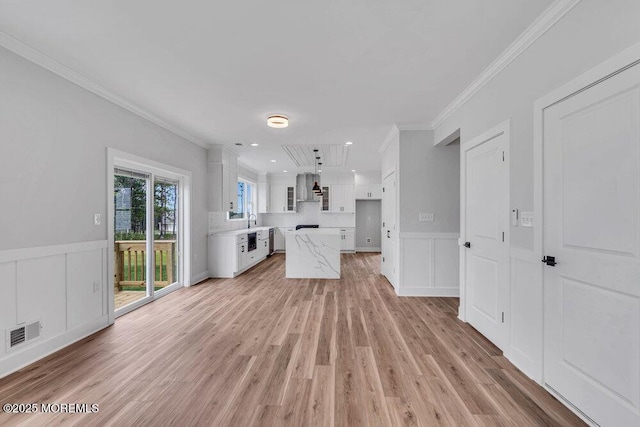 12 Outsail Ave, Barnegat, NJ 08005 - unfurnished living room featuring crown molding, a decorative wall, light wood-type flooring, wainscoting, and recessed lighting
