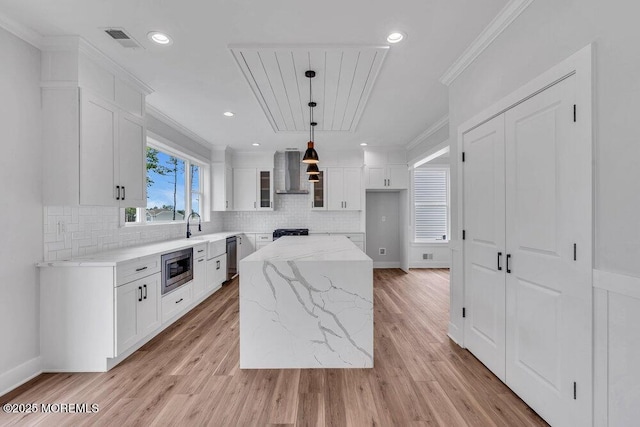12 Outsail Ave, Barnegat, NJ 08005 - kitchen with wall chimney range hood, stainless steel microwave, white cabinetry, light stone countertops, and decorative backsplash