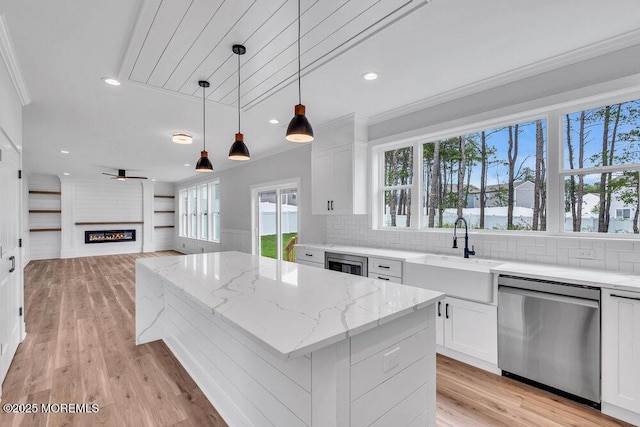 12 Outsail Ave, Barnegat, NJ 08005 - kitchen with stainless steel dishwasher, ornamental molding, a kitchen island, white cabinets, and light stone countertops