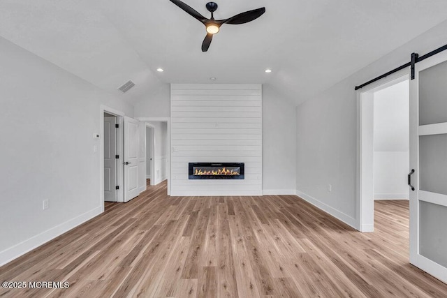 12 Outsail Ave, Barnegat, NJ 08005 - unfurnished living room featuring vaulted ceiling, ceiling fan, a large fireplace, a barn door, and wood finished floors
