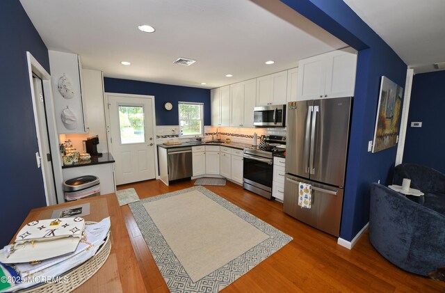 244D Jefferson Ct, Lakewood, NJ 08701 - kitchen featuring stainless steel appliances, white cabinets, dark countertops, dark wood finished floors, and decorative backsplash