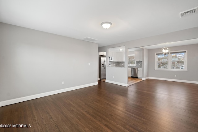 23 Island Dr, Brick, NJ 08724 - unfurnished living room featuring a chandelier and dark wood-type flooring