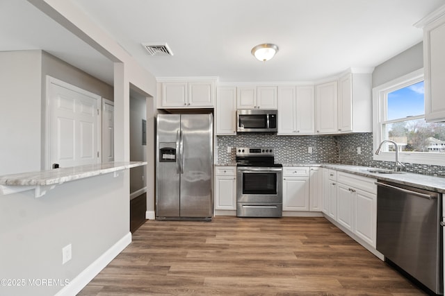 23 Island Dr, Brick, NJ 08724 - kitchen featuring stainless steel appliances, tasteful backsplash, wood finished floors, light stone counters, and white cabinets