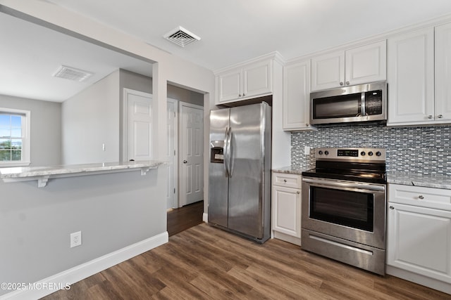 23 Island Dr, Brick, NJ 08724 - kitchen featuring stainless steel appliances, white cabinetry, tasteful backsplash, dark wood-type flooring, and light stone countertops
