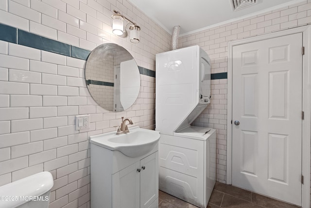 23 Island Dr, Brick, NJ 08724 - bathroom with tile walls, stacked washer and clothes dryer, vanity, and tile patterned floors