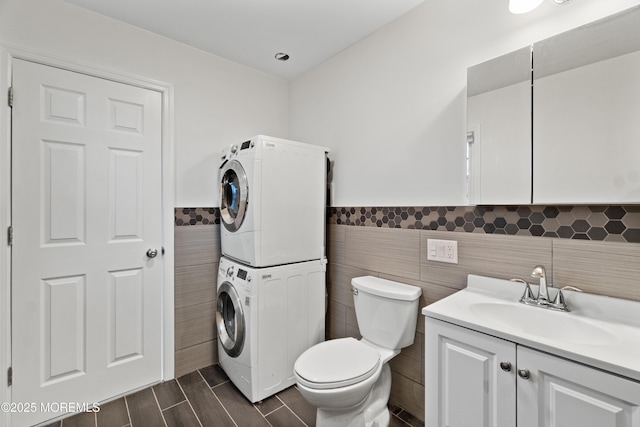 23 Island Dr, Brick, NJ 08724 - bathroom featuring stacked washer / dryer, tile walls, wainscoting, vanity, and wood tiled floors