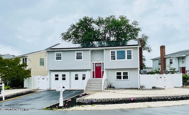 23 Island Dr, Brick, NJ 08724 - bi-level home featuring asphalt driveway and an attached garage