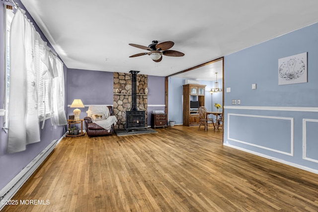1341 1st Ave, Toms River, NJ 08757 - living area with baseboard heating, a wood stove, a ceiling fan, and wood finished floors