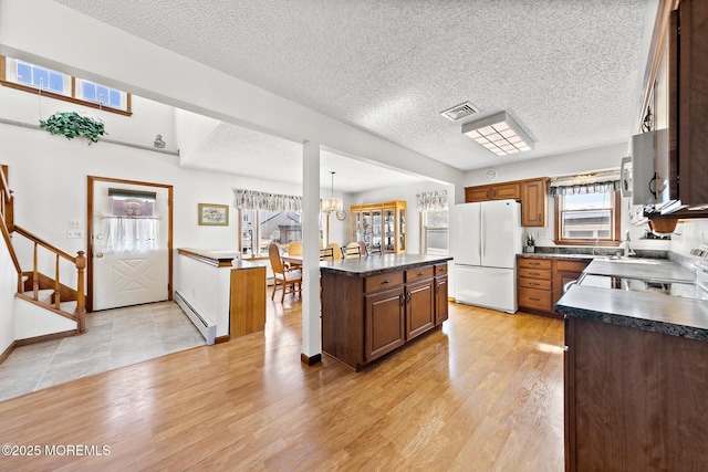 8 Mary Alice Rd, Beach Haven West, NJ 08050 - kitchen featuring freestanding refrigerator, a baseboard radiator, dark countertops, light wood-style flooring, and a textured ceiling