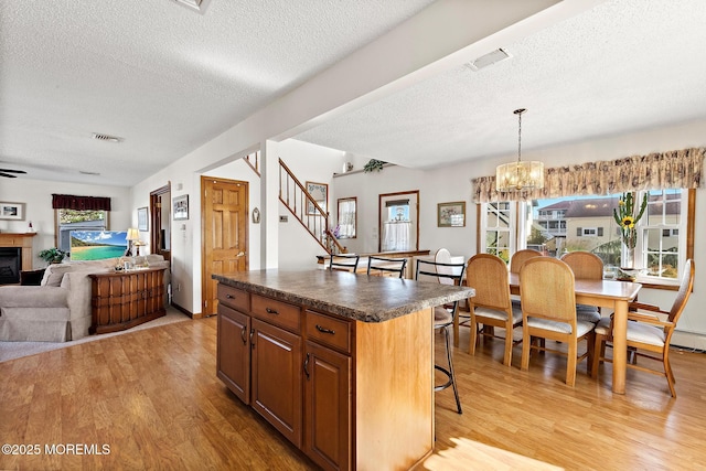8 Mary Alice Rd, Beach Haven West, NJ 08050 - kitchen with light wood-type flooring, dark countertops, a textured ceiling, a fireplace, and open floor plan