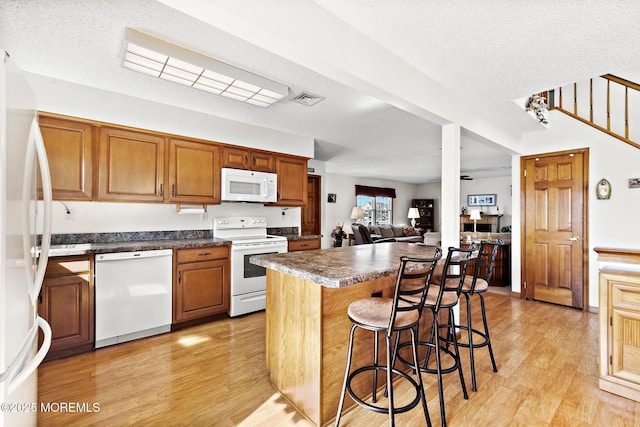 8 Mary Alice Rd, Beach Haven West, NJ 08050 - kitchen with white appliances, light wood finished floors, a kitchen breakfast bar, dark countertops, and a textured ceiling