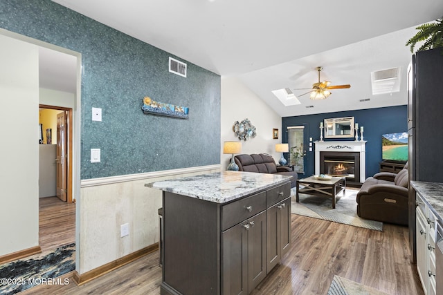 1887 Crimson Ct, Toms River, NJ 08755 - kitchen with a ceiling fan, wood finished floors, a skylight, a lit fireplace, and open floor plan