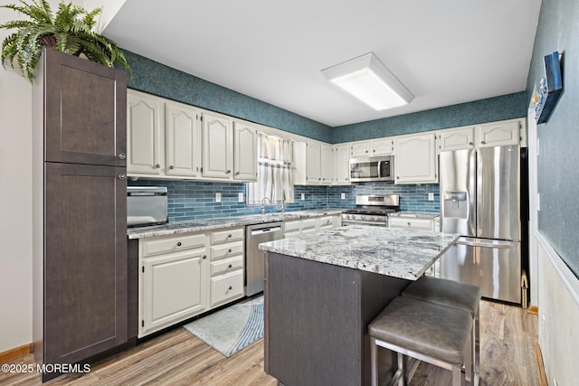 1887 Crimson Ct, Toms River, NJ 08755 - kitchen featuring stainless steel appliances, light wood finished floors, tasteful backsplash, white cabinetry, and a breakfast bar area