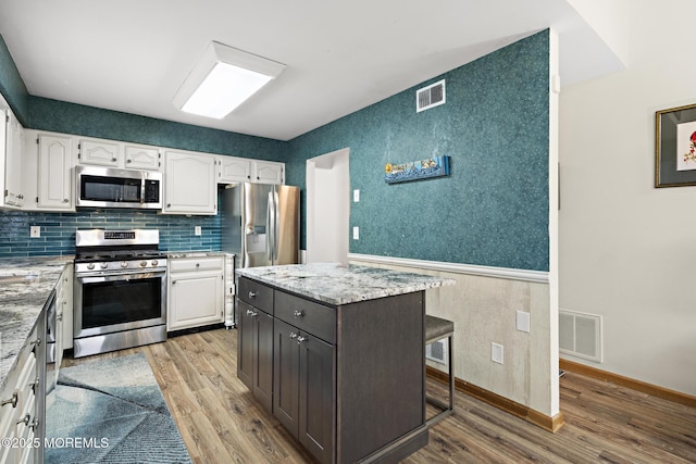 1887 Crimson Ct, Toms River, NJ 08755 - kitchen with stainless steel appliances, white cabinetry, light wood-type flooring, and light stone countertops
