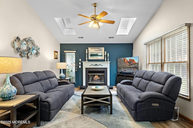 1887 Crimson Ct, Toms River, NJ 08755 - living room featuring a skylight, lofted ceiling, ceiling fan, wood finished floors, and a glass covered fireplace