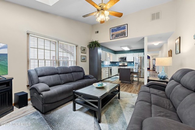 1887 Crimson Ct, Toms River, NJ 08755 - living room with light wood finished floors, ceiling fan, plenty of natural light, and a high ceiling