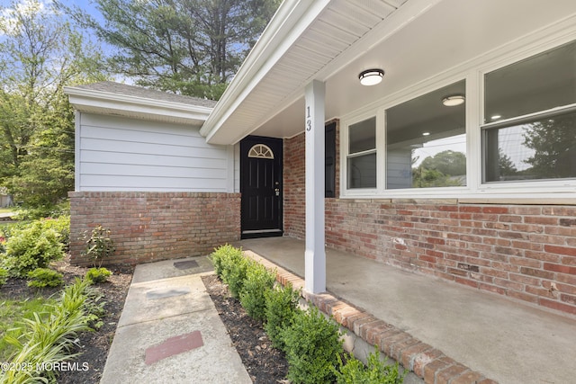 13 Pinehurst Dr, Little Egg Harbor, NJ 08087 - property entrance featuring brick siding, roof with shingles, and covered porch