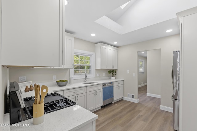 13 Pinehurst Dr, Little Egg Harbor, NJ 08087 - kitchen featuring appliances with stainless steel finishes, a skylight, white cabinetry, light wood-type flooring, and recessed lighting