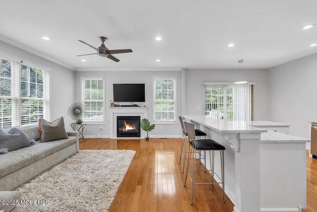 76 Deepwater Cir, Manalapan, NJ 07726 - living room with a fireplace with flush hearth, light wood-style flooring, ornamental molding, recessed lighting, and ceiling fan