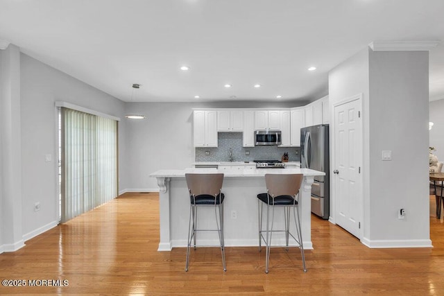 76 Deepwater Cir, Manalapan, NJ 07726 - kitchen with stainless steel appliances, light countertops, white cabinets, a center island, and light wood finished floors