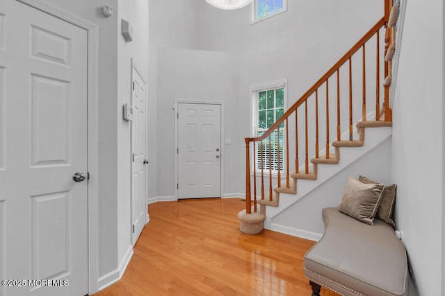 76 Deepwater Cir, Manalapan, NJ 07726 - entryway featuring stairway, light wood-style flooring, and a towering ceiling