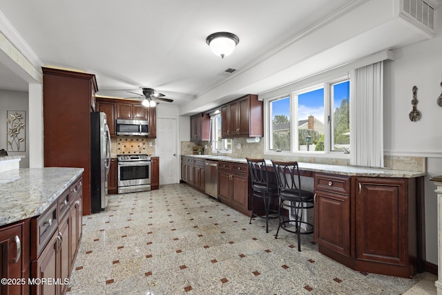 16 8th Ave, Monroe, NJ 08831 - kitchen with stainless steel appliances, a ceiling fan, backsplash, light stone counters, and light flooring
