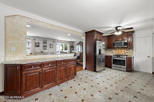 16 8th Ave, Monroe, NJ 08831 - kitchen with stainless steel appliances, a peninsula, ceiling fan, backsplash, and light stone counters