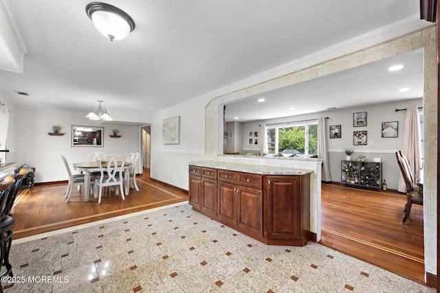 16 8th Ave, Monroe, NJ 08831 - kitchen with a chandelier, crown molding, light stone countertops, light wood finished floors, and a peninsula