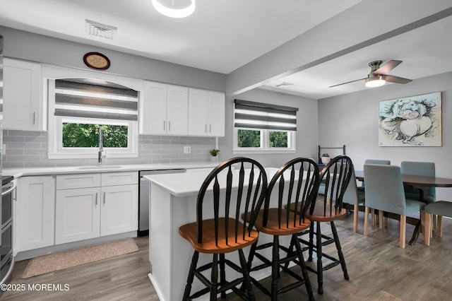 180 Grand Ave, Atlantic Highlands, NJ 07716 - kitchen with stainless steel appliances, a kitchen bar, light countertops, decorative backsplash, and wood finished floors