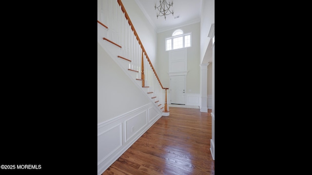 18 Sage St, Holmdel, NJ 07733 - foyer entrance featuring ornamental molding, stairway, light wood finished floors, a decorative wall, and a chandelier