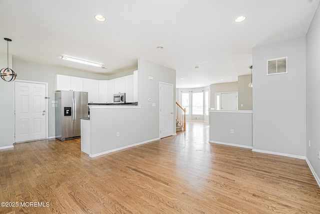 9 Mioduski Ct, Parlin, NJ 08859 - unfurnished living room featuring light wood-style flooring, recessed lighting, and stairs