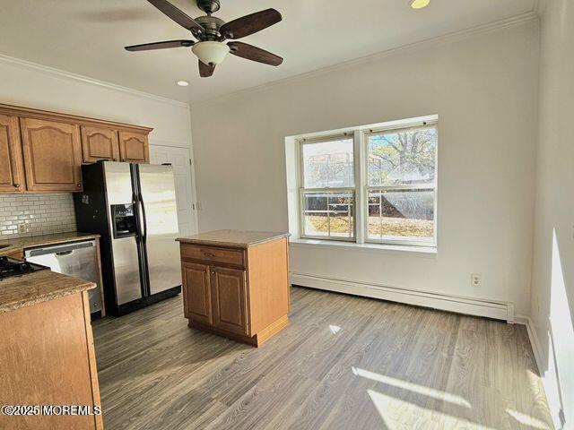 19 Sunrise Blvd, Forked River, NJ 08731 - kitchen with baseboard heating, stainless steel appliances, decorative backsplash, ceiling fan, and light wood-style floors