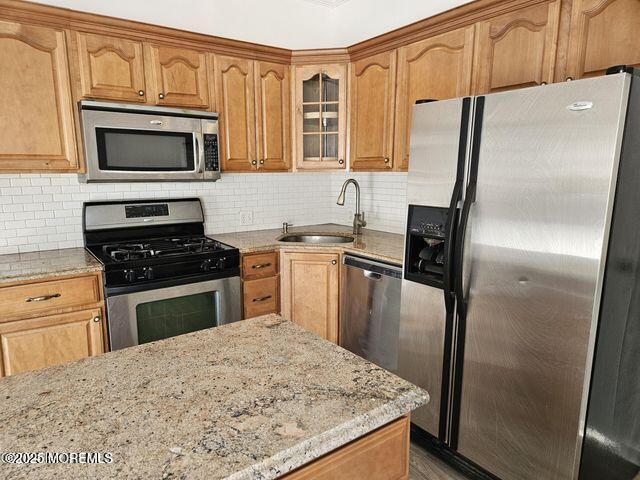 19 Sunrise Blvd, Forked River, NJ 08731 - kitchen with appliances with stainless steel finishes, light stone counters, backsplash, and glass insert cabinets