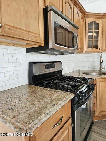 19 Sunrise Blvd, Forked River, NJ 08731 - kitchen with appliances with stainless steel finishes, backsplash, glass insert cabinets, and light stone counters