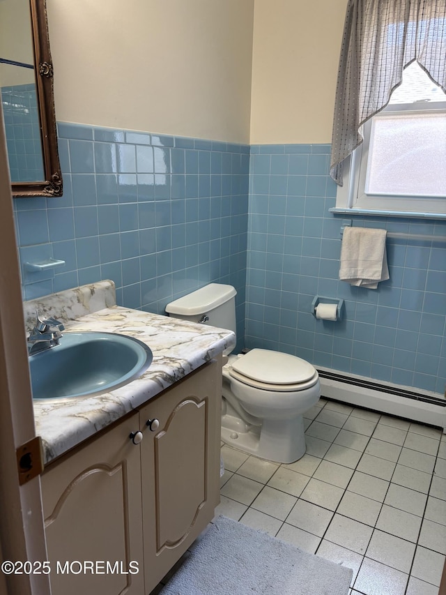 458 Jamaica Blvd, Toms River, NJ 08757 - half bathroom featuring baseboard heating, vanity, tile walls, tile patterned floors, and a wainscoted wall