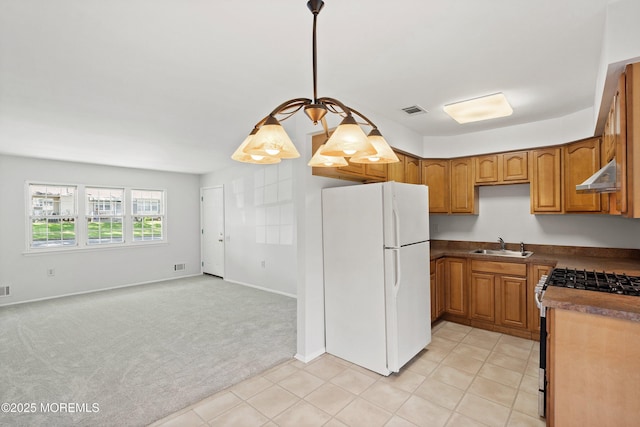 10 Haven Dr Unit B, Matawan, NJ 07747 - kitchen with freestanding refrigerator, under cabinet range hood, gas stove, dark countertops, and light carpet