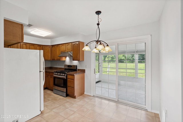 10 Haven Dr Unit B, Matawan, NJ 07747 - kitchen with freestanding refrigerator, stainless steel gas range oven, under cabinet range hood, dark countertops, and brown cabinetry