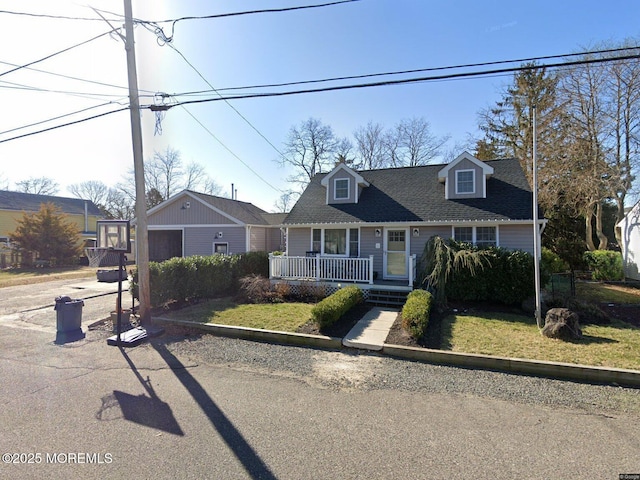 32 E Long Branch Ave, Ocean Gate, NJ 08740 - new england style home with a porch, roof with shingles, a garage, and driveway