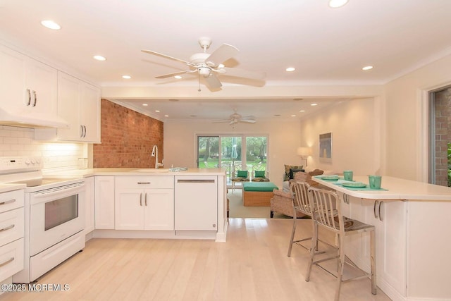 68 Linden Ct, Spring Lake Heights, NJ 07762 - kitchen with white appliances, a peninsula, under cabinet range hood, open floor plan, and light wood-style floors