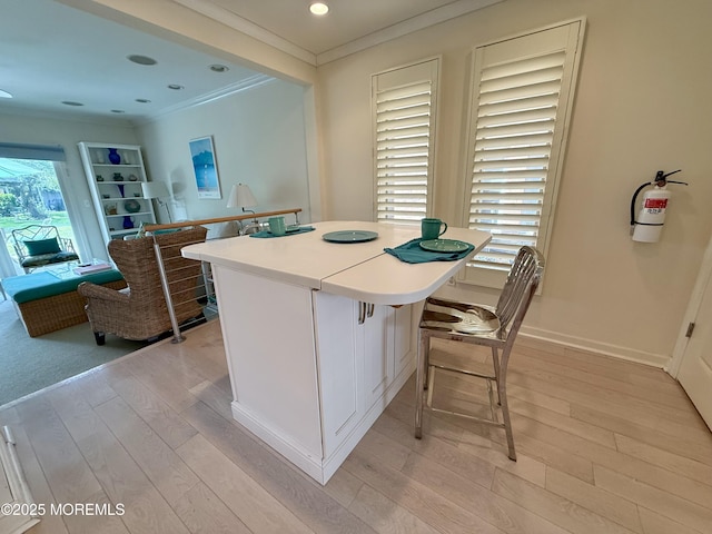 68 Linden Ct, Spring Lake Heights, NJ 07762 - kitchen with crown molding, light wood-style flooring, a center island, a breakfast bar, and light countertops