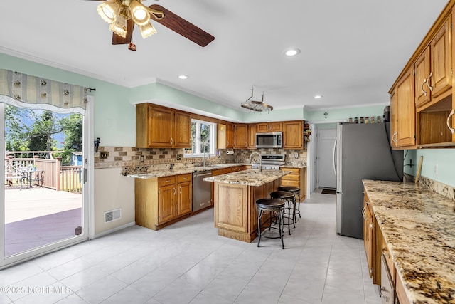 70 Desai Ct, Freehold, NJ 07728 - kitchen featuring stainless steel appliances, ceiling fan, a center island with sink, tasteful backsplash, and crown molding