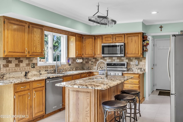 70 Desai Ct, Freehold, NJ 07728 - kitchen featuring stainless steel appliances, light stone countertops, ornamental molding, a center island with sink, and tasteful backsplash