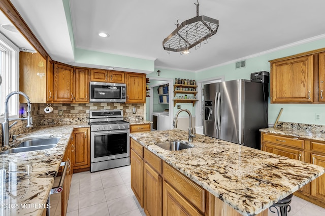 70 Desai Ct, Freehold, NJ 07728 - kitchen with stainless steel appliances, washing machine and clothes dryer, brown cabinetry, crown molding, and recessed lighting