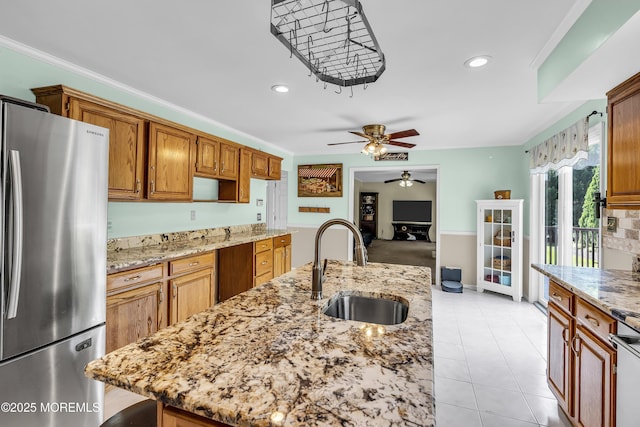 70 Desai Ct, Freehold, NJ 07728 - kitchen with freestanding refrigerator, a ceiling fan, light stone counters, crown molding, and an island with sink