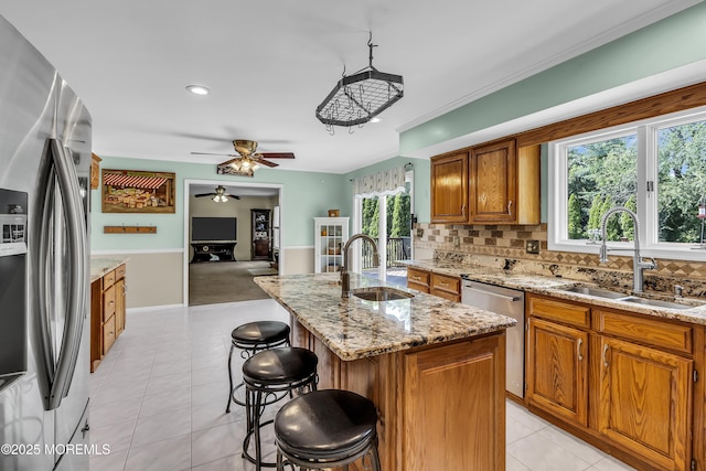 70 Desai Ct, Freehold, NJ 07728 - kitchen with appliances with stainless steel finishes, decorative backsplash, ceiling fan, brown cabinets, and a breakfast bar area